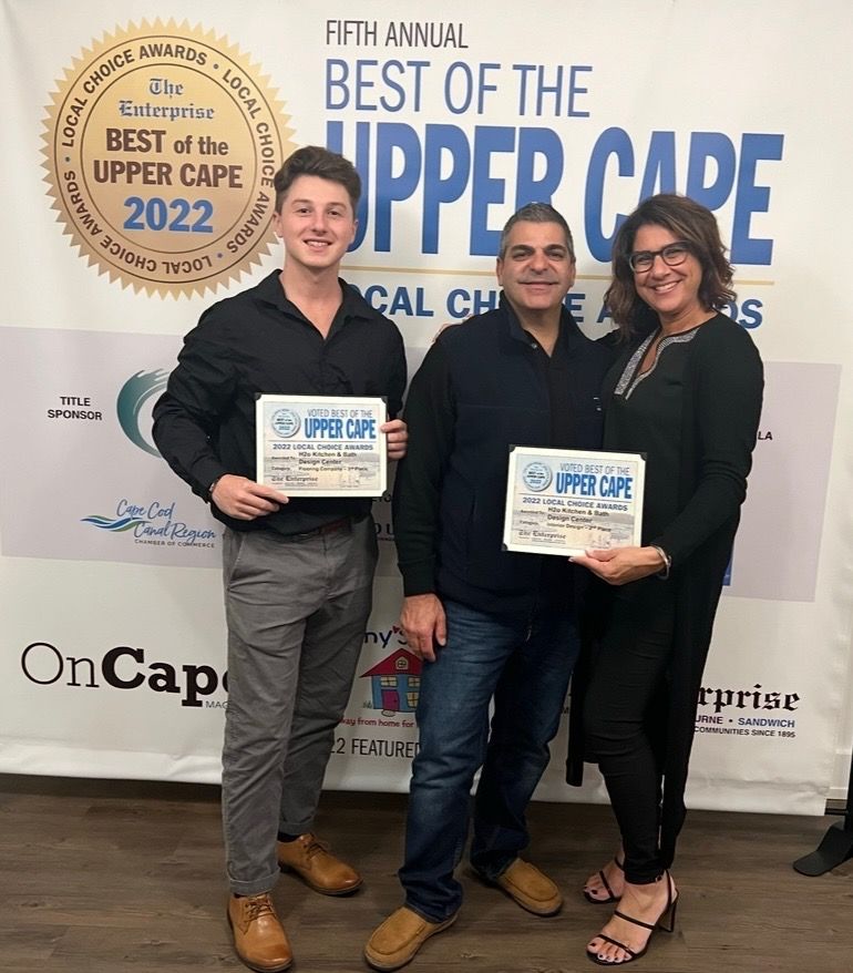 Three people are standing in front of a sign that says best of the upper cape 2022
