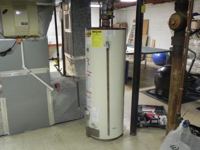 Basement utility room with furnace, water heater, ductwork, and storage shelves