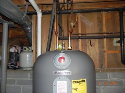 Basement water heater with pipes and ductwork in a utility room