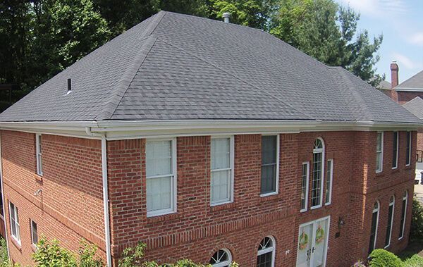 A large brick house with a gray roof and white trim