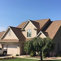 A large house with a car parked in front of it.