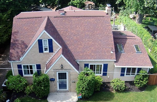 An aerial view of a house with a red roof and blue shutters