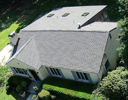 An aerial view of a house with a gray roof