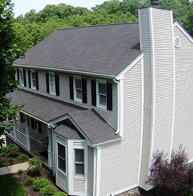 A white house with a gray roof and black shutters