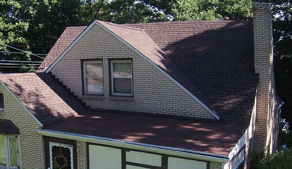 A brick house with a brown roof and a chimney