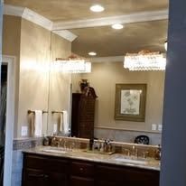 Bathroom with a large mirror, double sink, and dark brown cabinets.