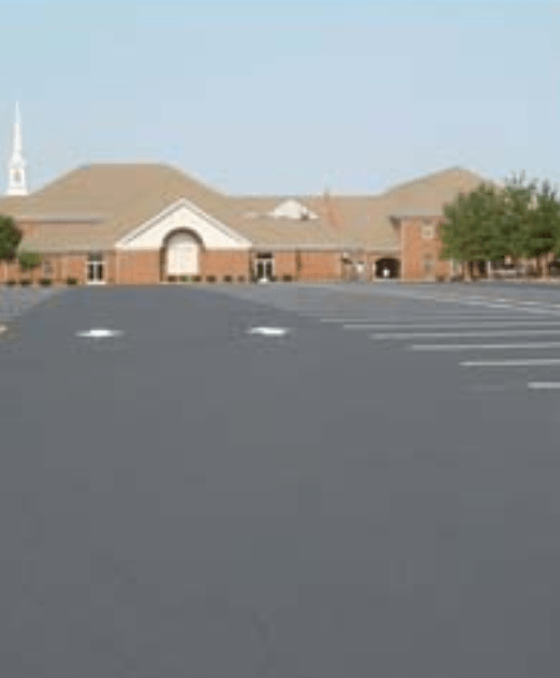 An empty parking lot with a church in the background