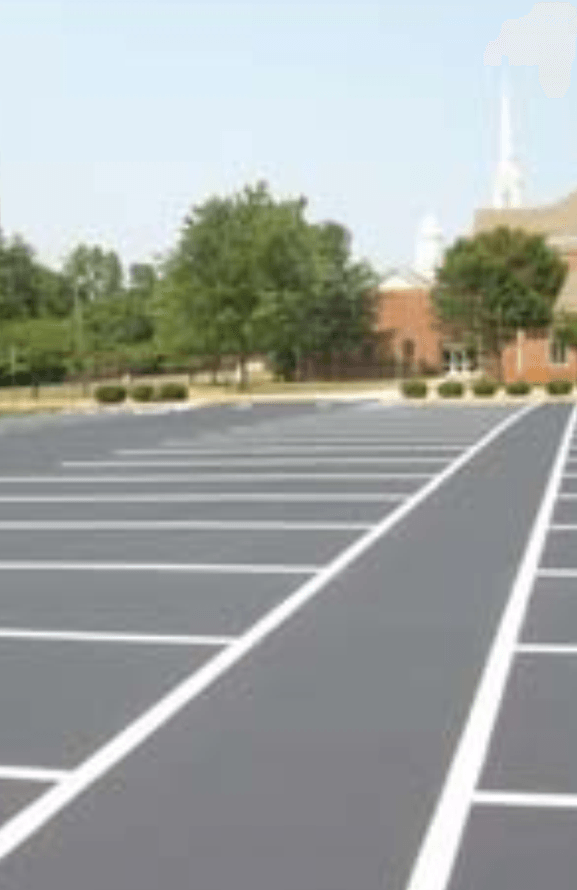 An empty parking lot with a church in the background