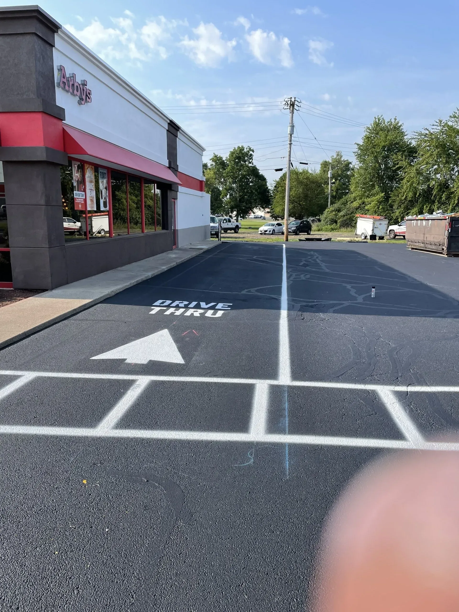 A drive-thru lane with a white arrow and 