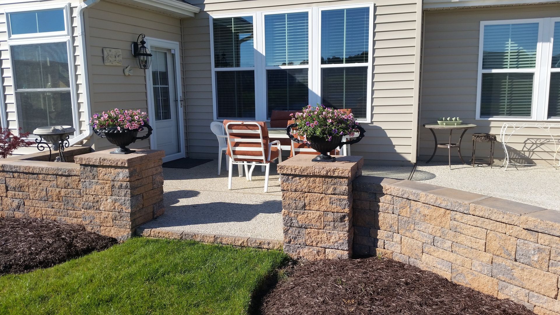 A house with a patio and a brick wall in front of it
