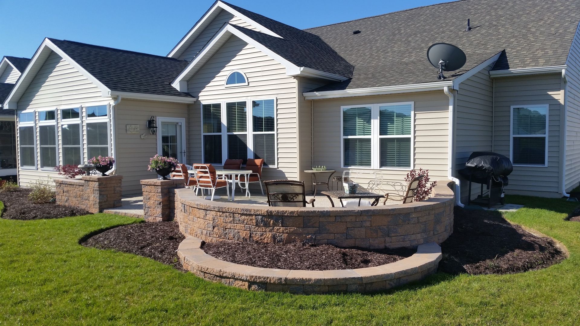 A large house with a patio and a fire pit in front of it.