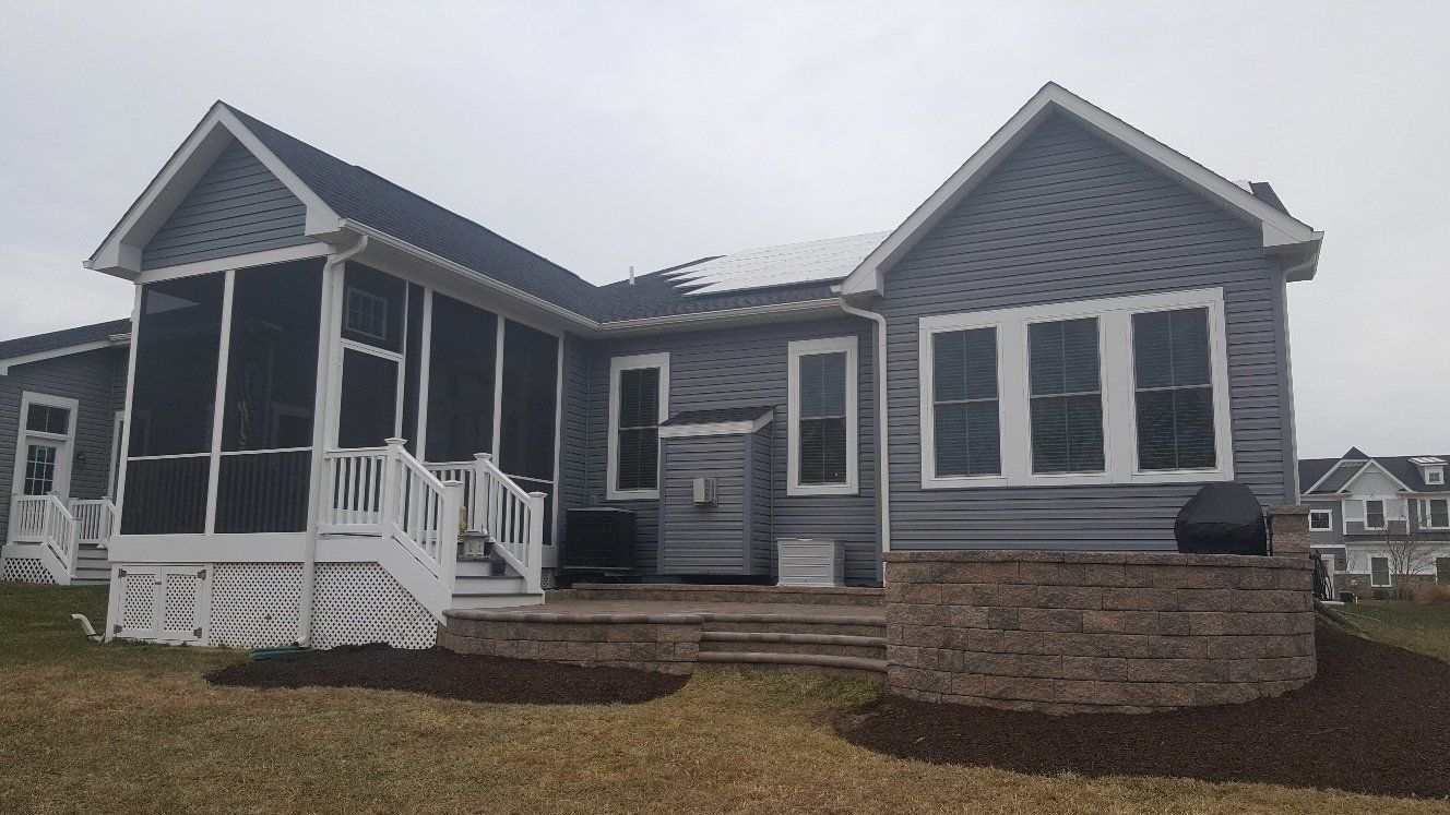 A large house with a screened in porch and stairs.
