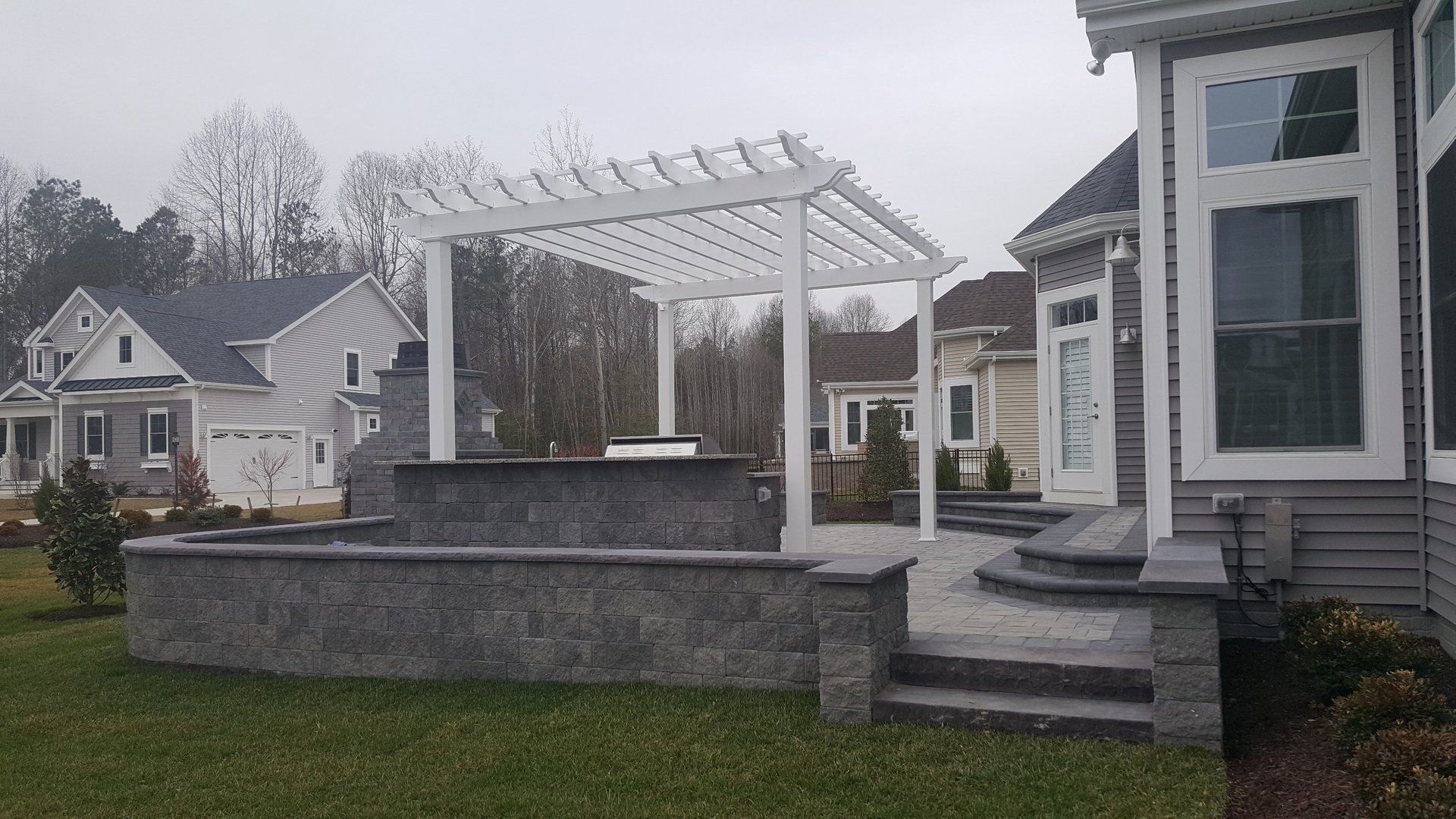 There is a pergola in the backyard of a house.