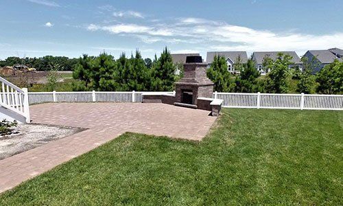 There is a fireplace in the backyard of a house.