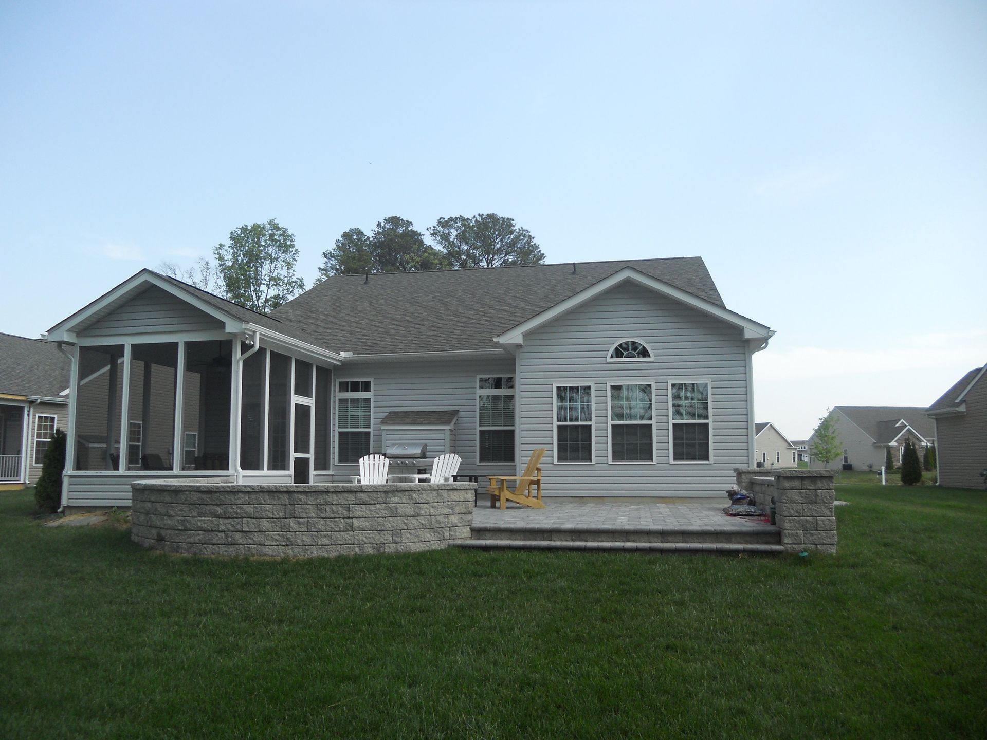 A house with a screened in porch and patio