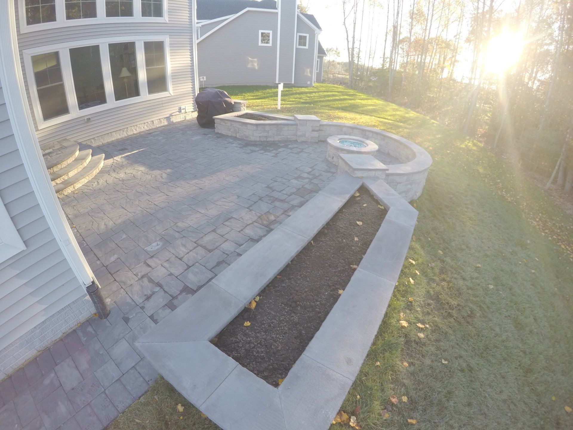 There is a fire pit in the backyard of a house.