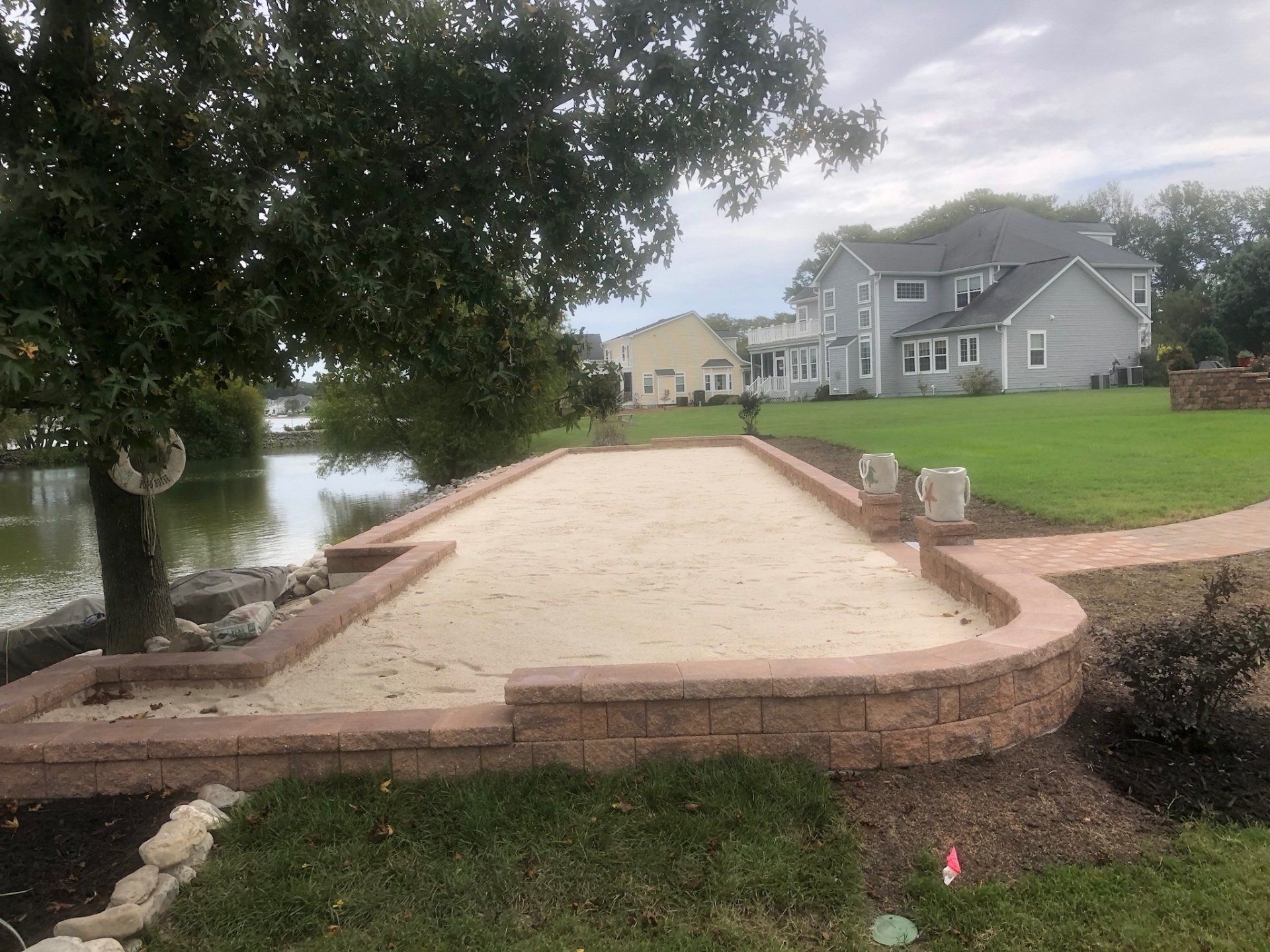 A bocce ball court is being built in the backyard of a house.