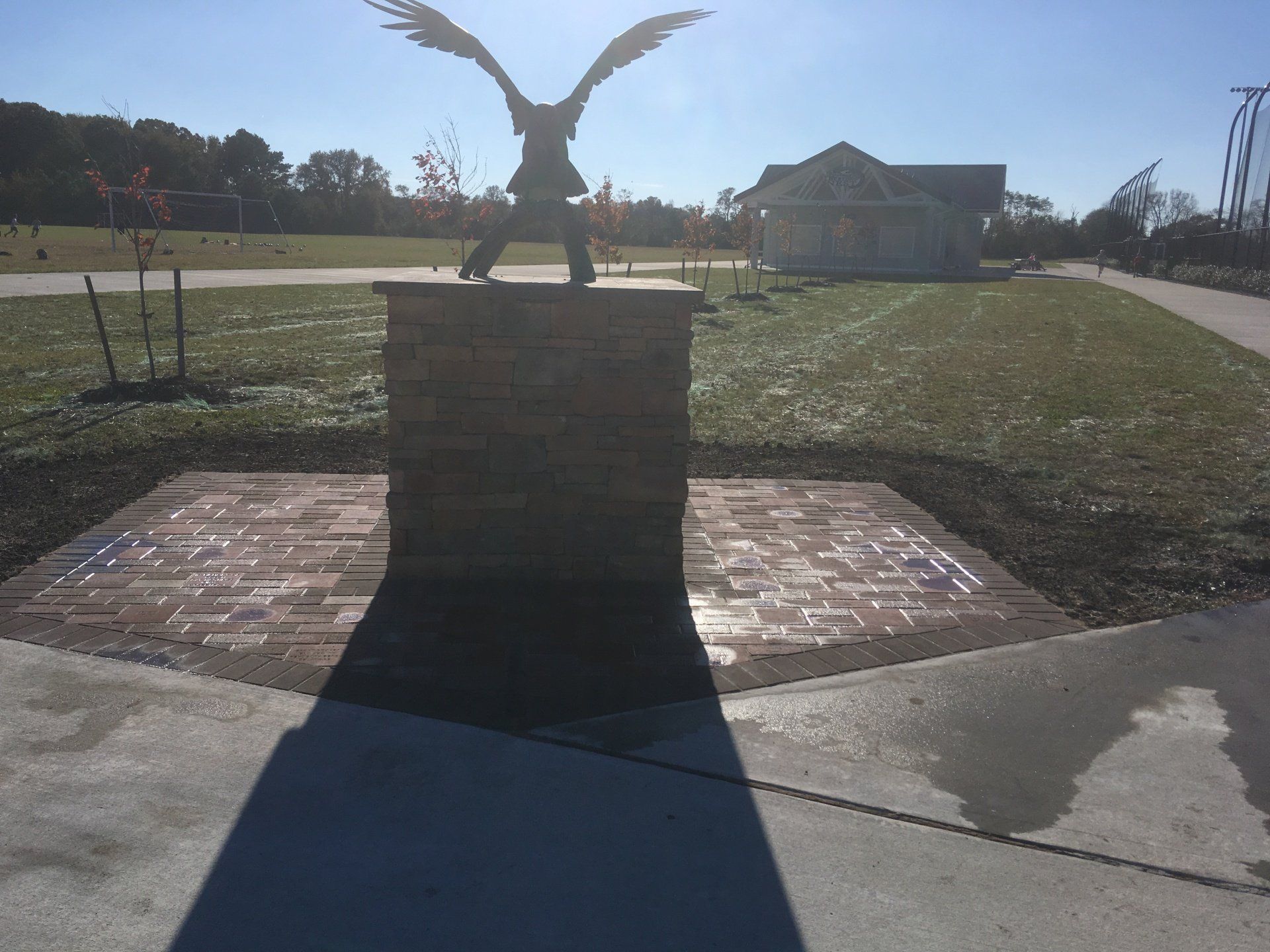 A statue of an eagle is sitting on top of a brick pillar
