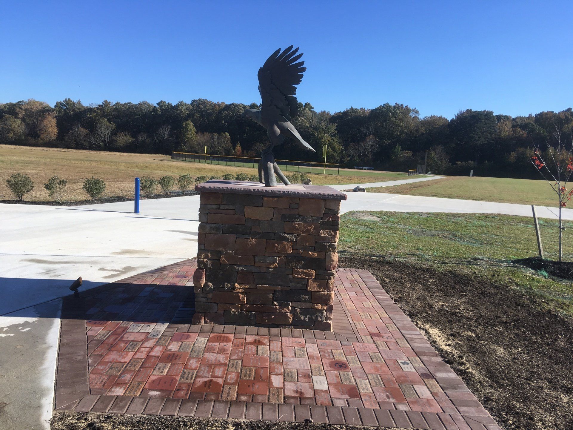 A statue of an eagle is sitting on top of a stone pillar