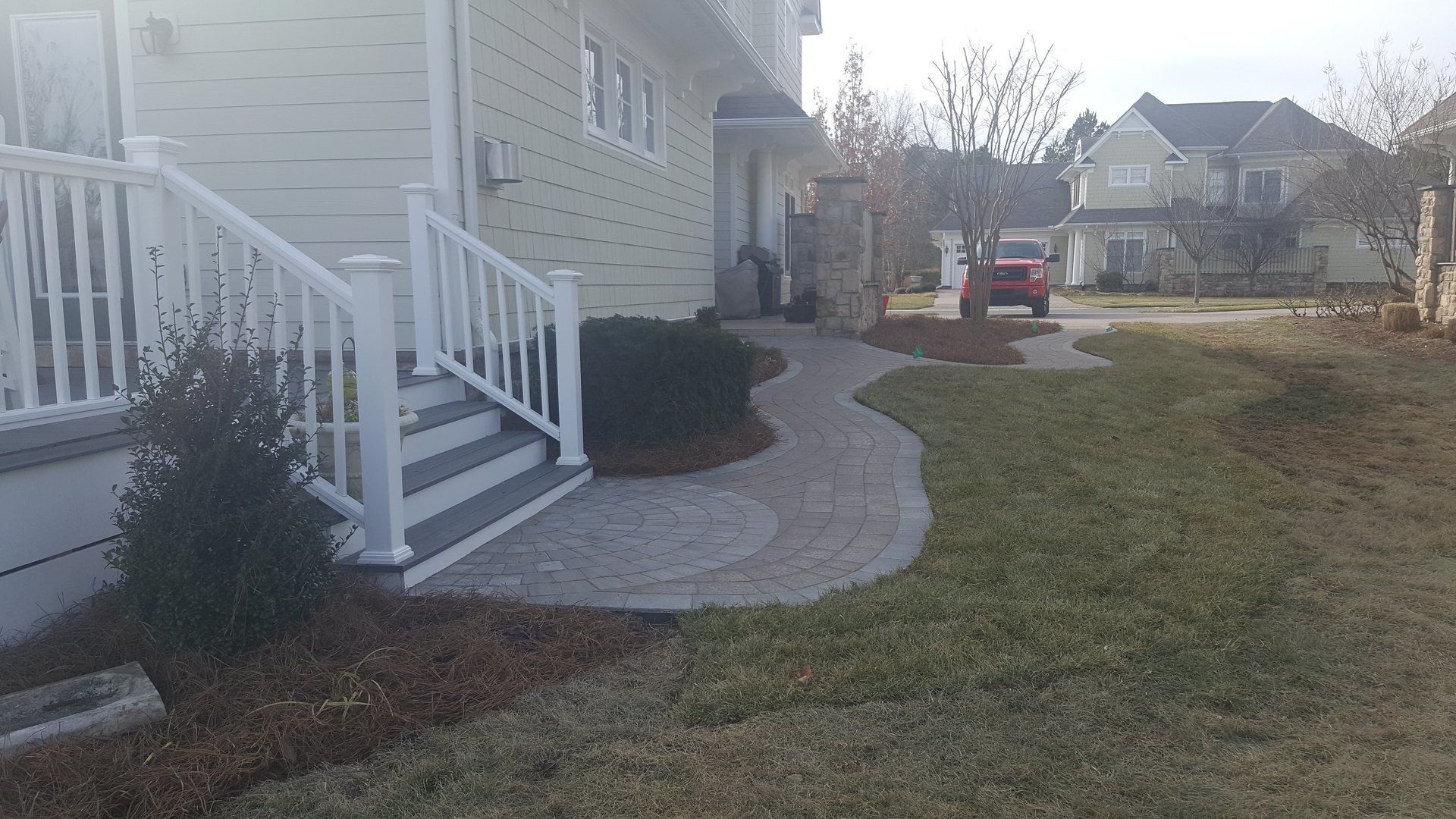 There is a walkway leading to the front of the house.