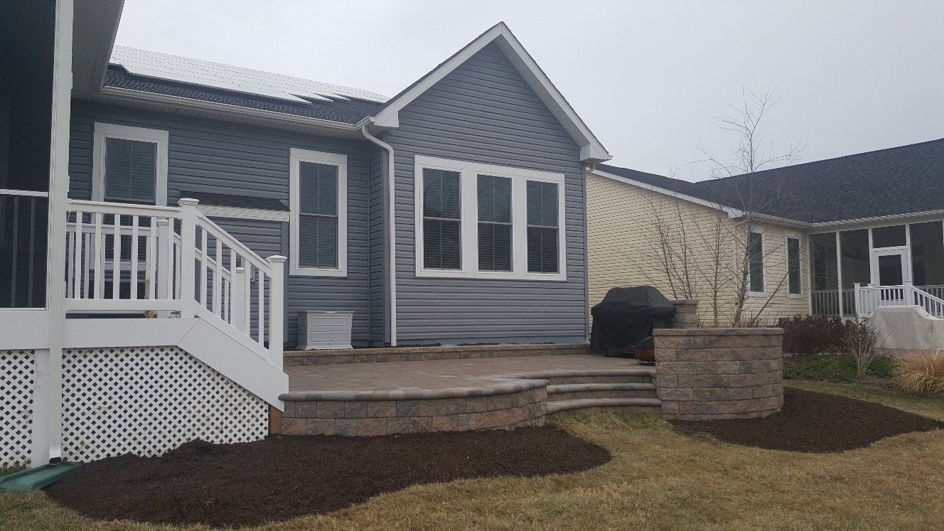 A house with a patio and stairs in front of it.