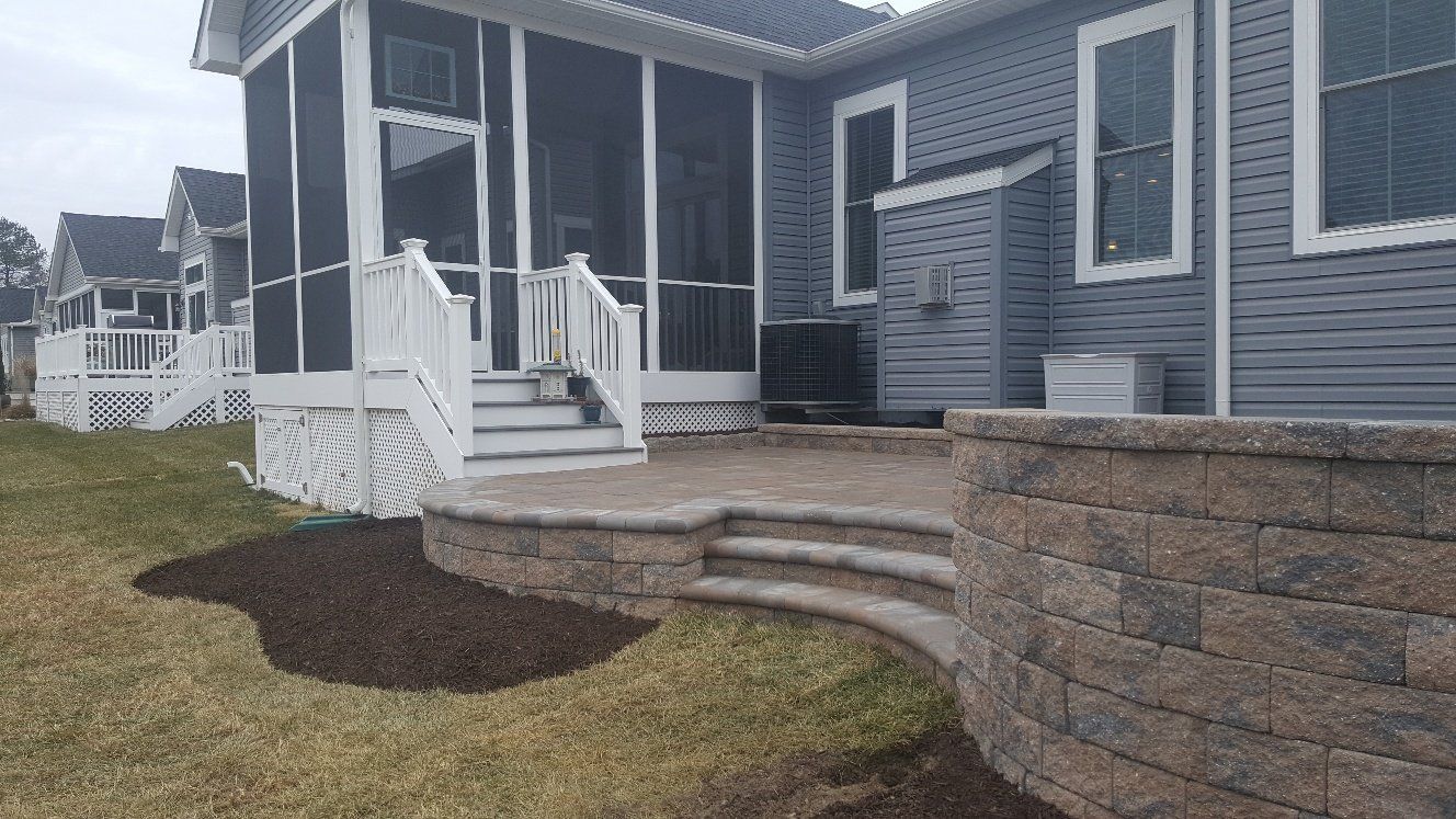 A house with a screened in porch and stairs.