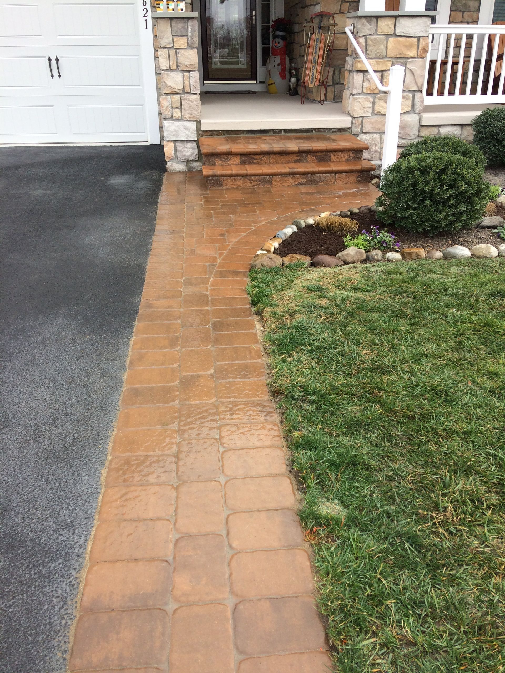 A brick walkway leading to the front door of a house.
