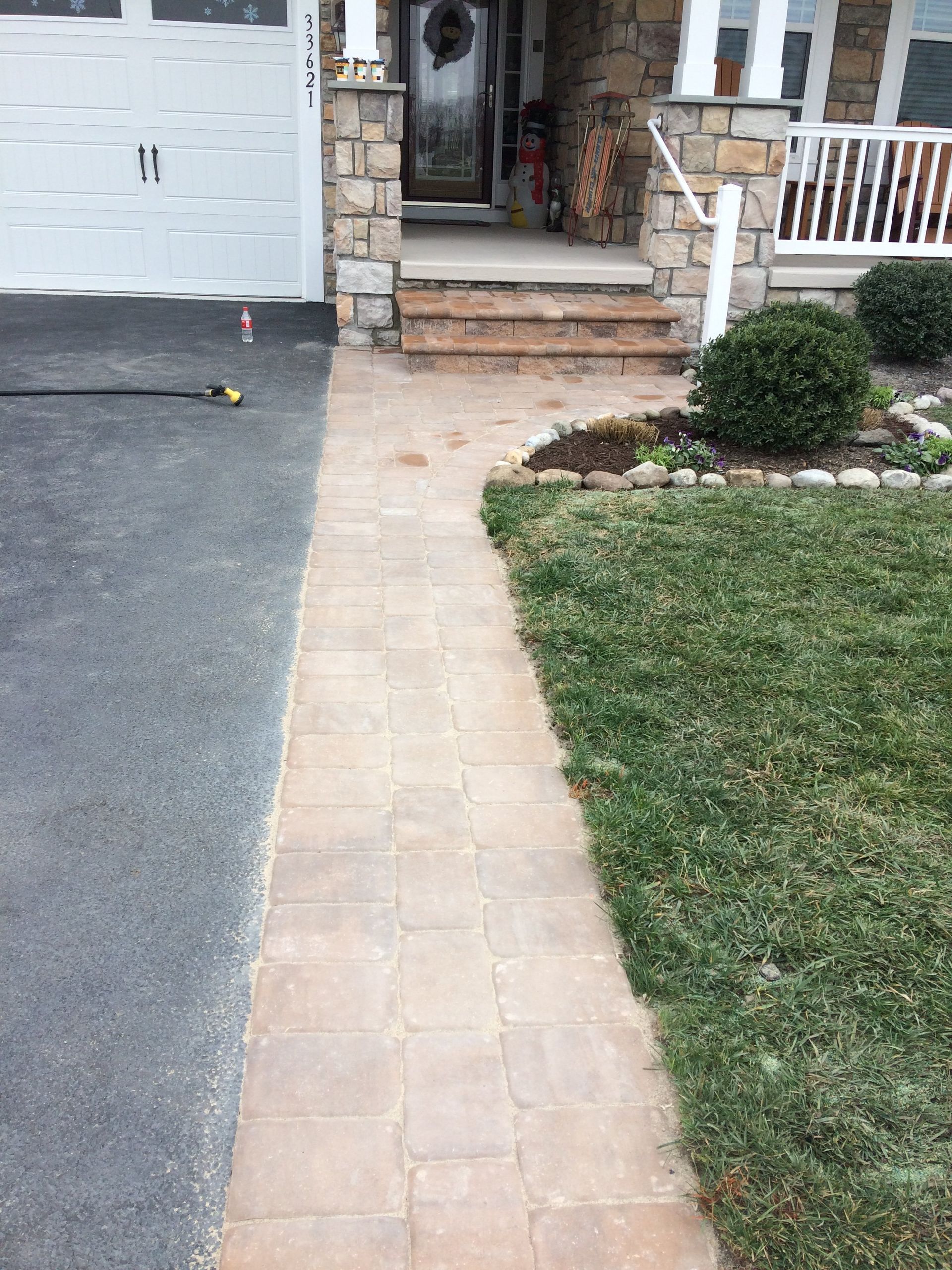 A brick walkway leading to the front door of a house.