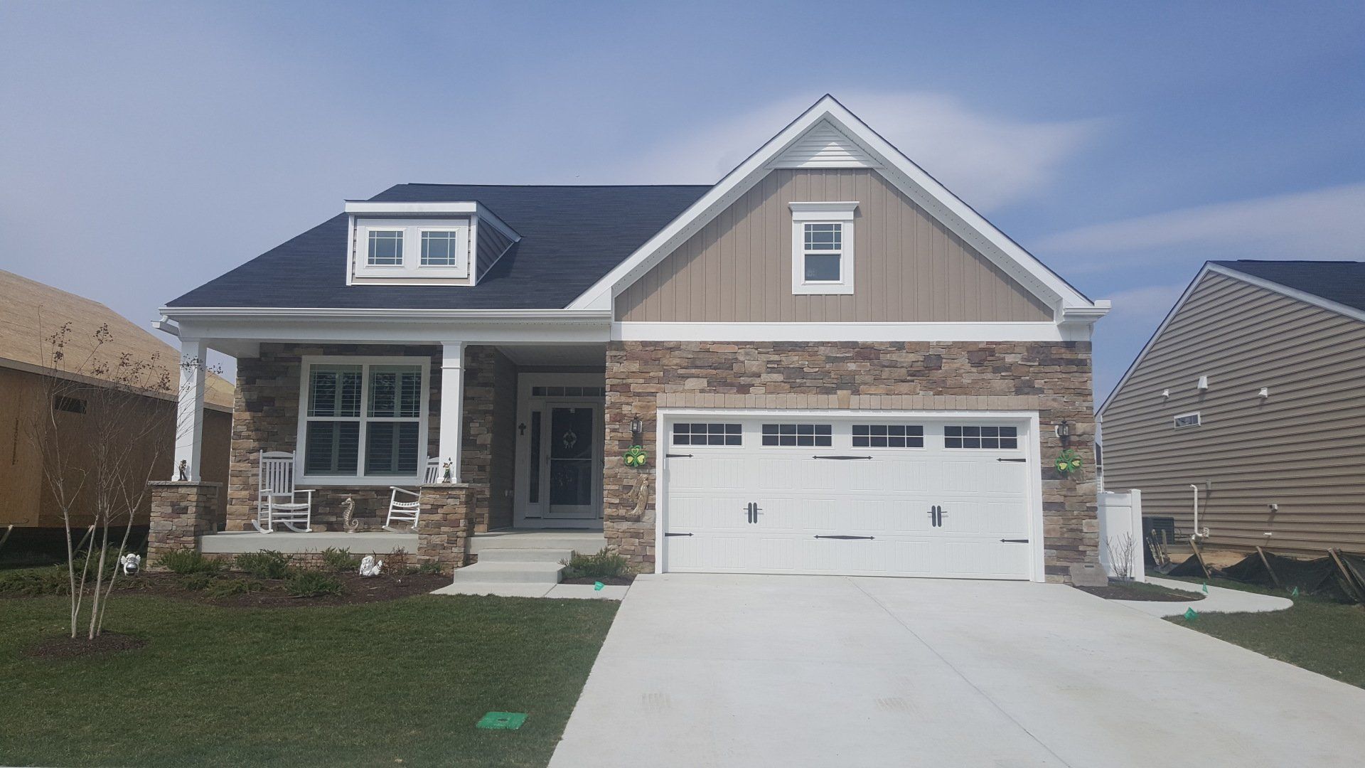 A brick house with a white garage door and a porch.