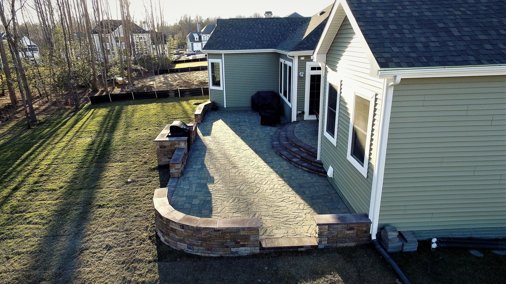 An aerial view of a house with a patio in front of it