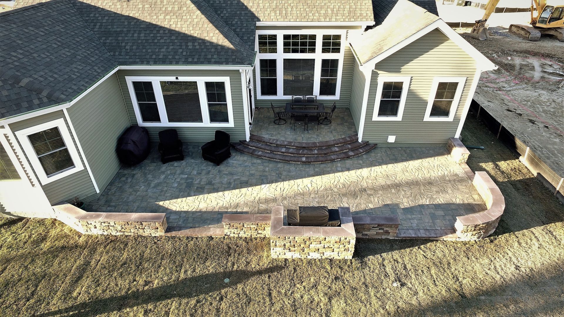 An aerial view of a house with a fire pit in the backyard.