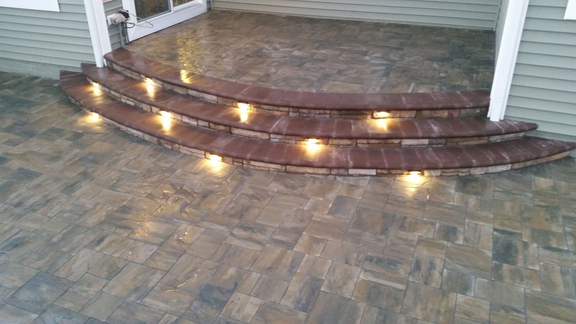 A set of steps leading up to a porch with lights on them.