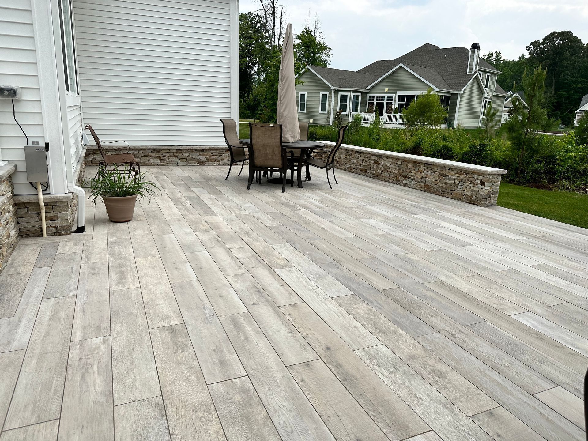 A large wooden deck with a table and chairs on it.