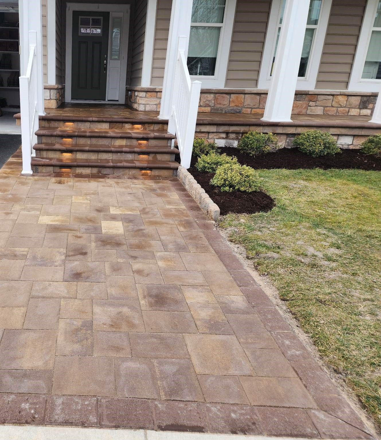 A brick walkway leading to the front door of a house