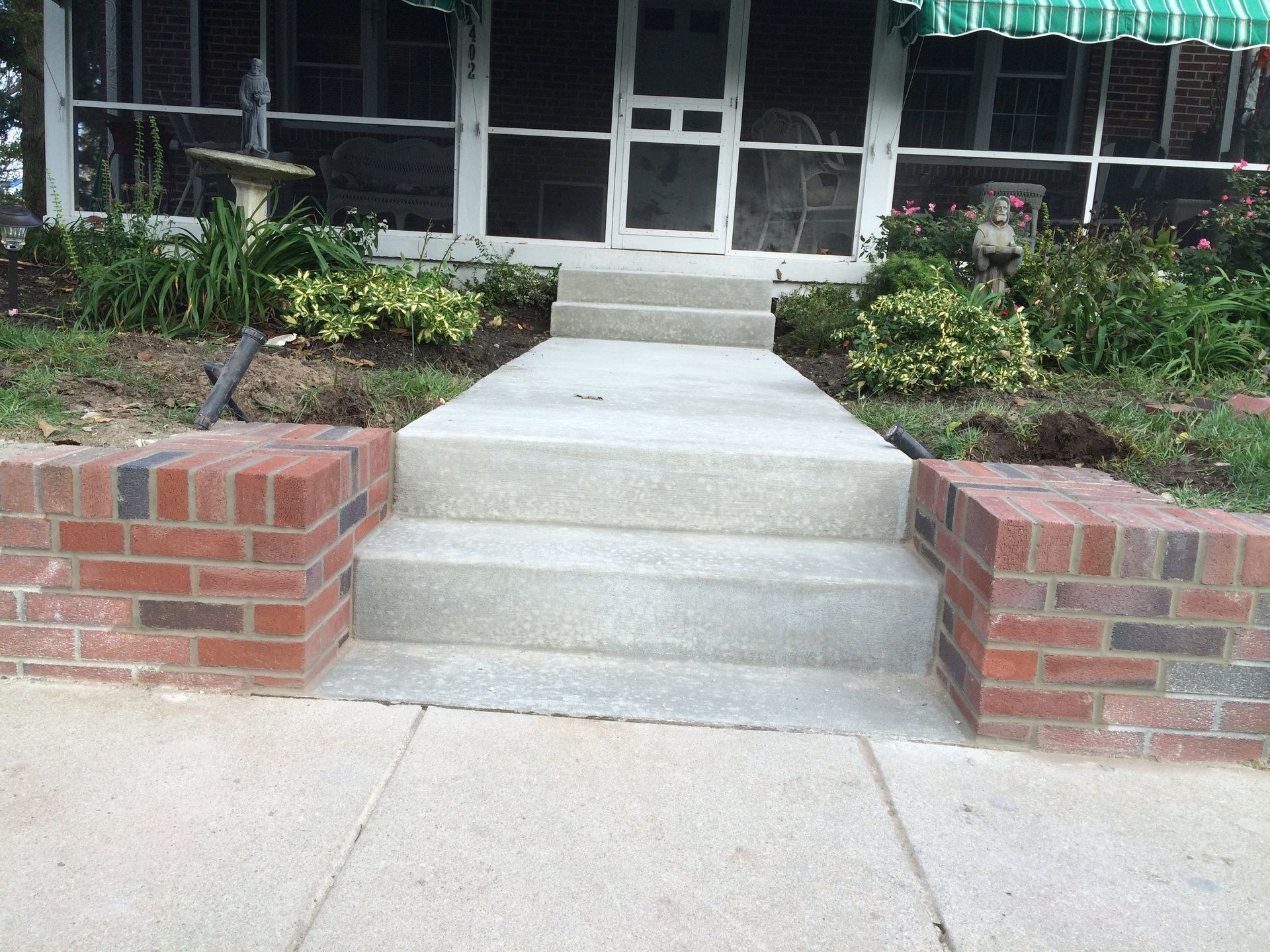 A screened in porch with concrete steps leading up to it