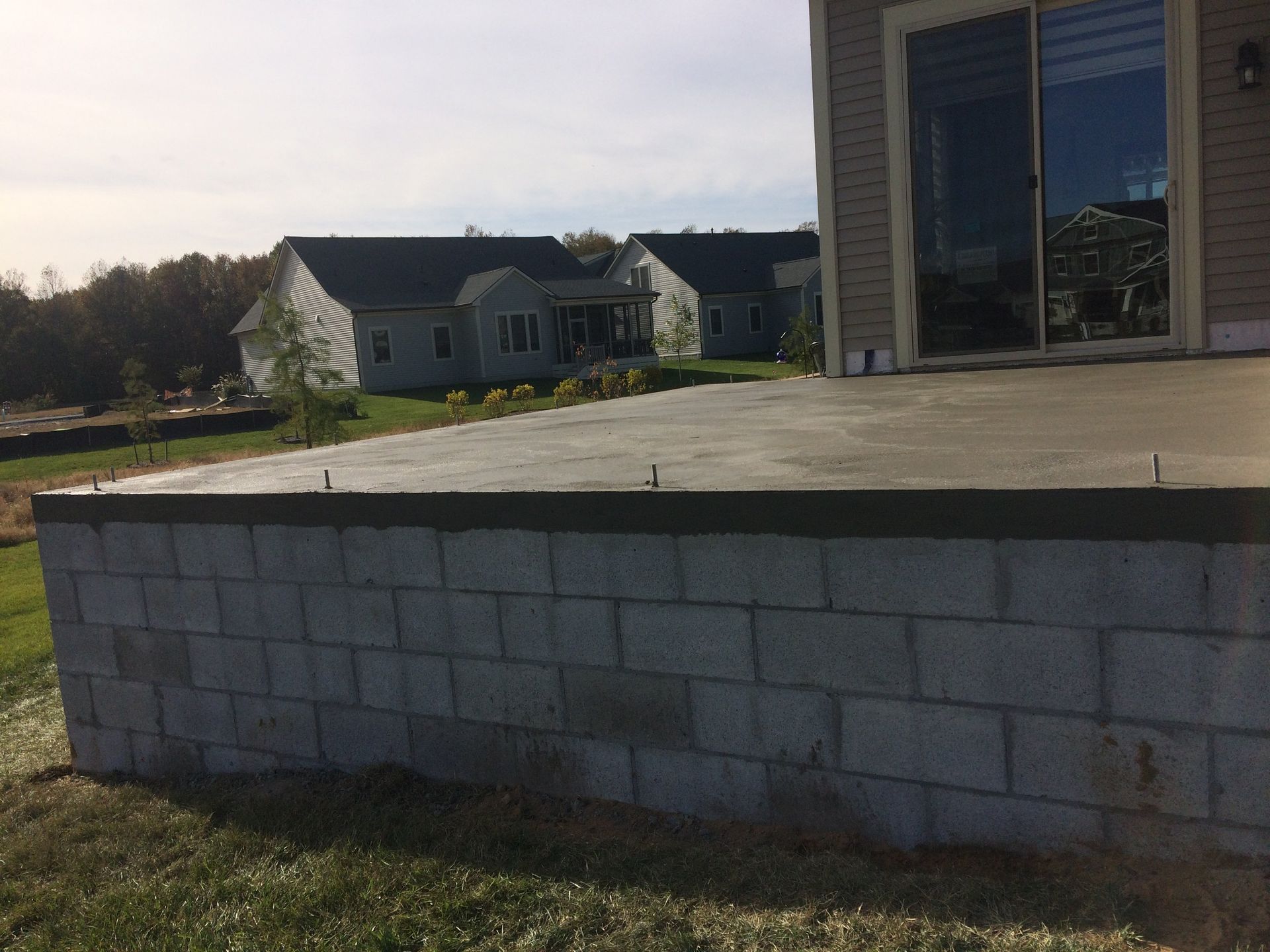 A concrete deck is being built in front of a house.