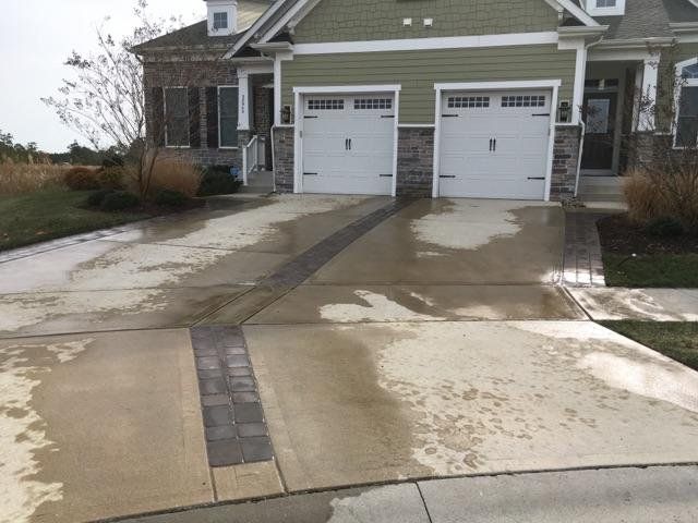 A driveway leading to a house with two garage doors