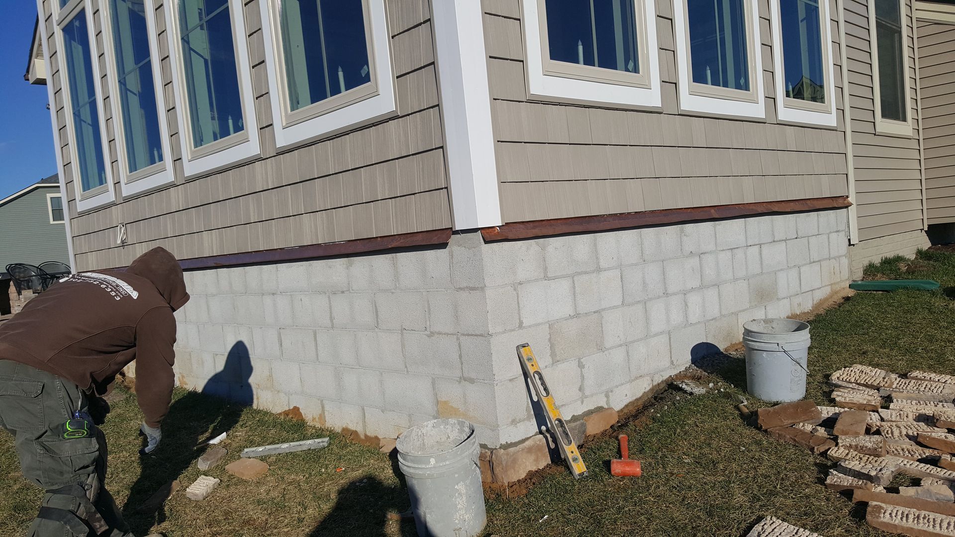 A man is working on the foundation of a house.