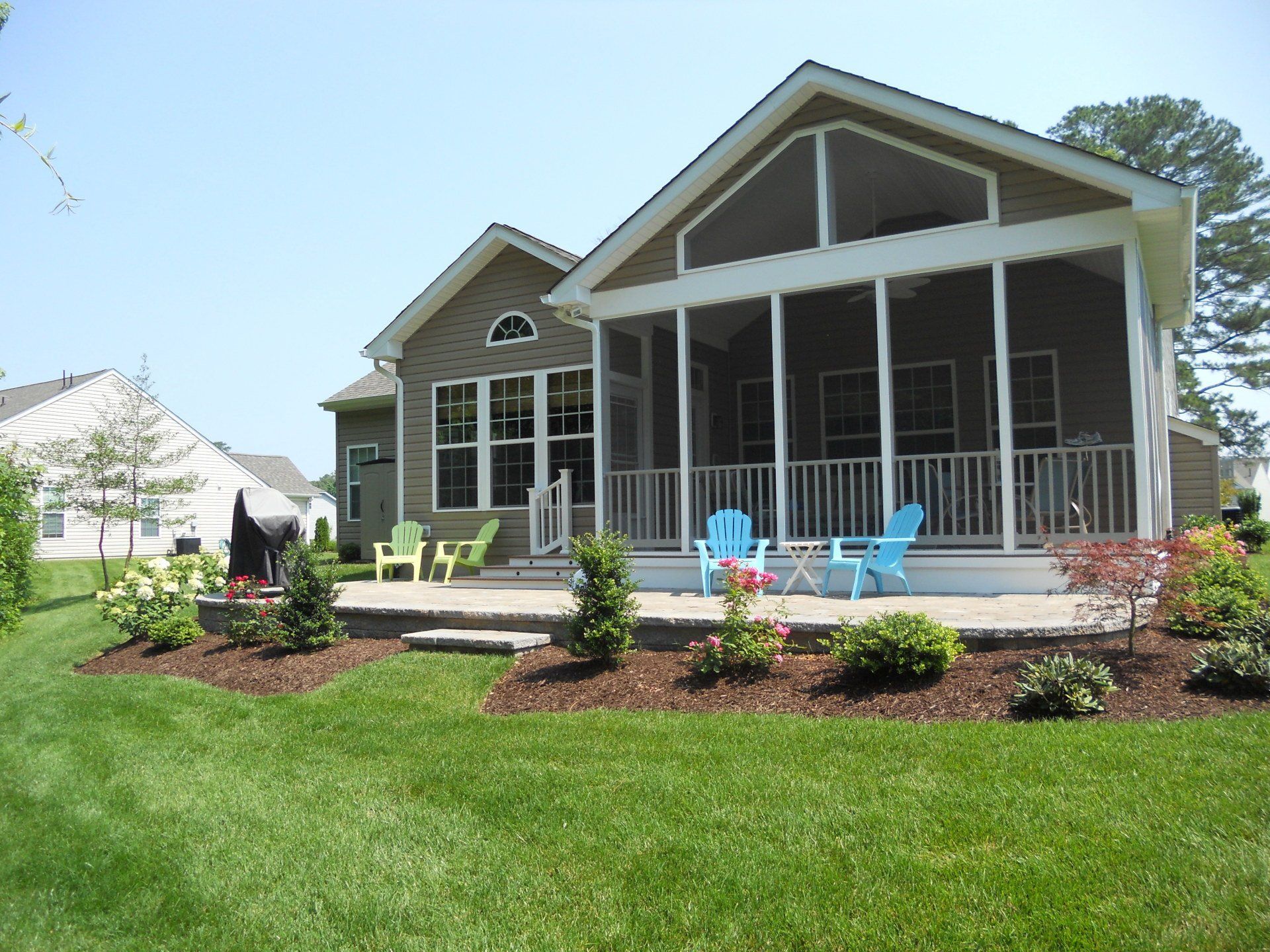 A house with a screened in porch and chairs on it