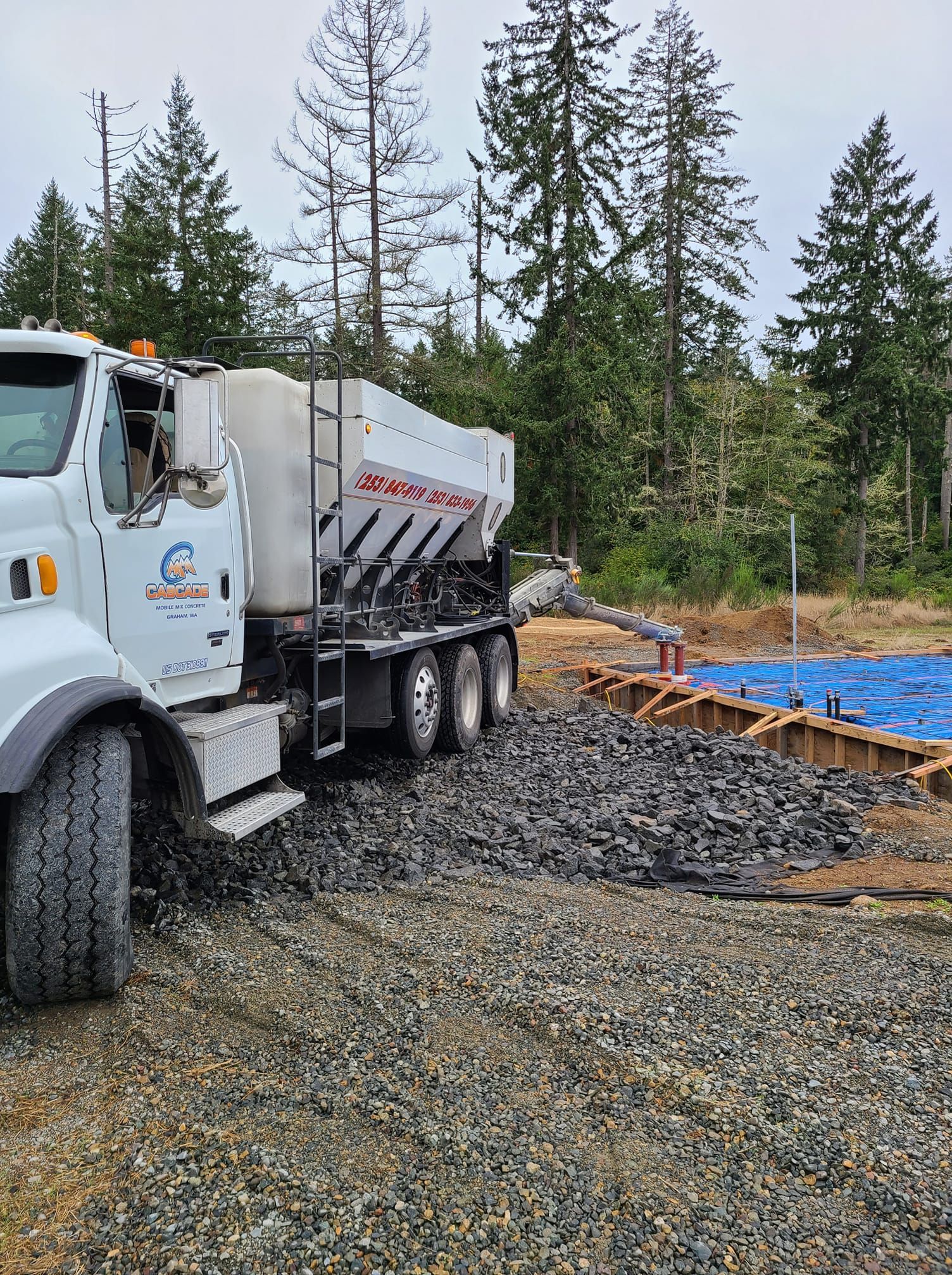 A white truck is driving down a gravel road.