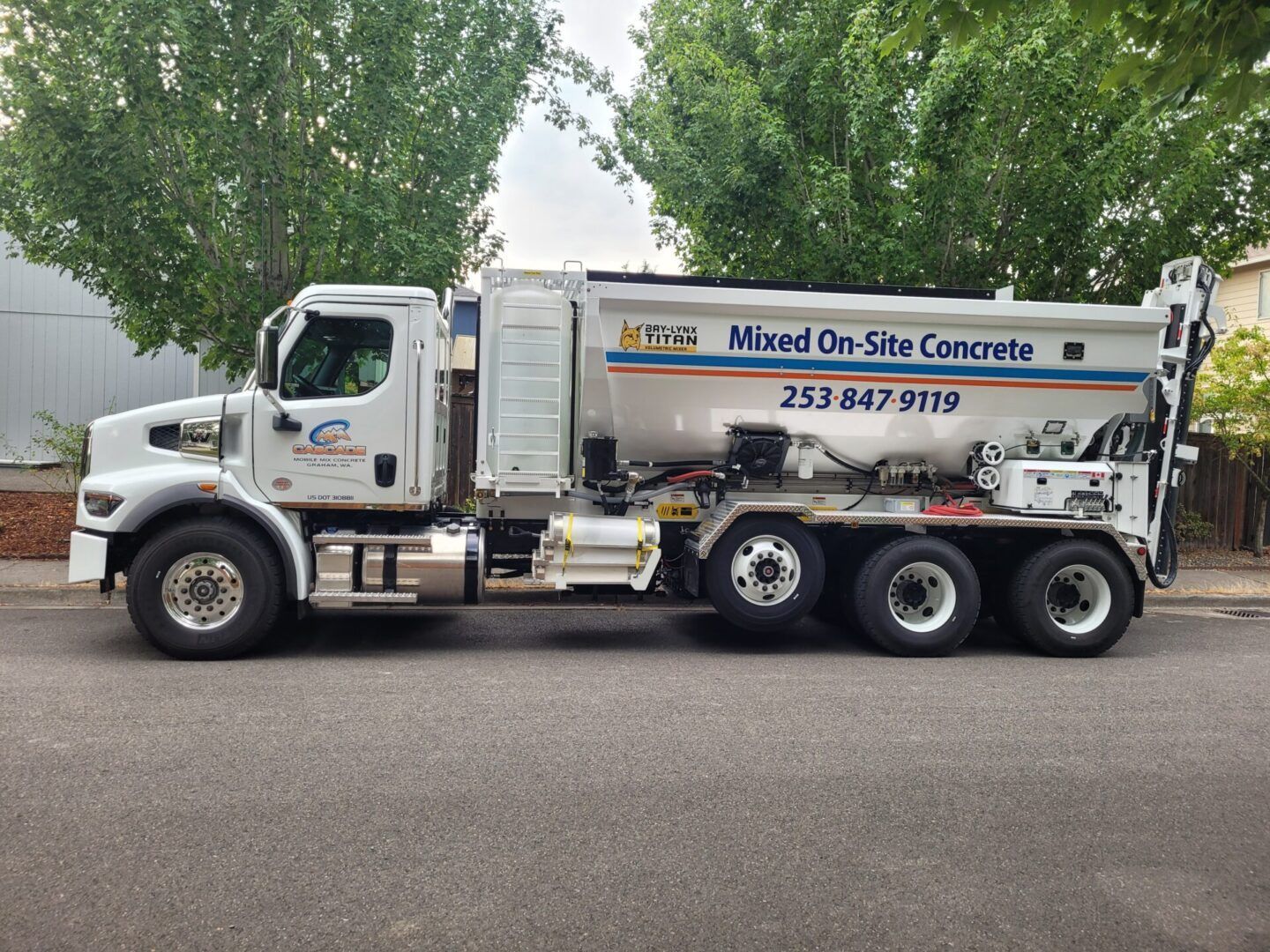 A white truck with a yellow trailer is parked on the side of the road.