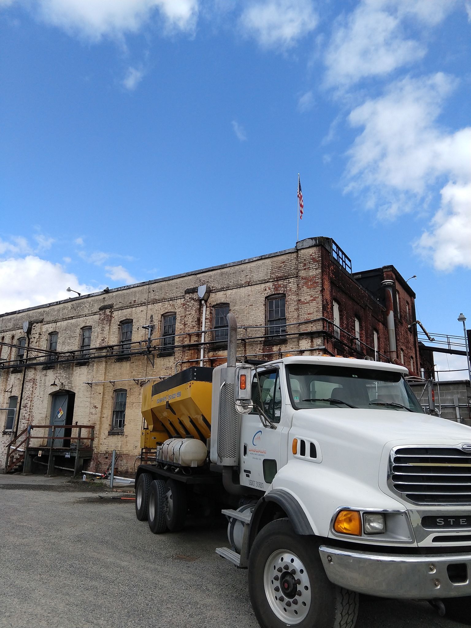 A white truck is parked in front of a large building
