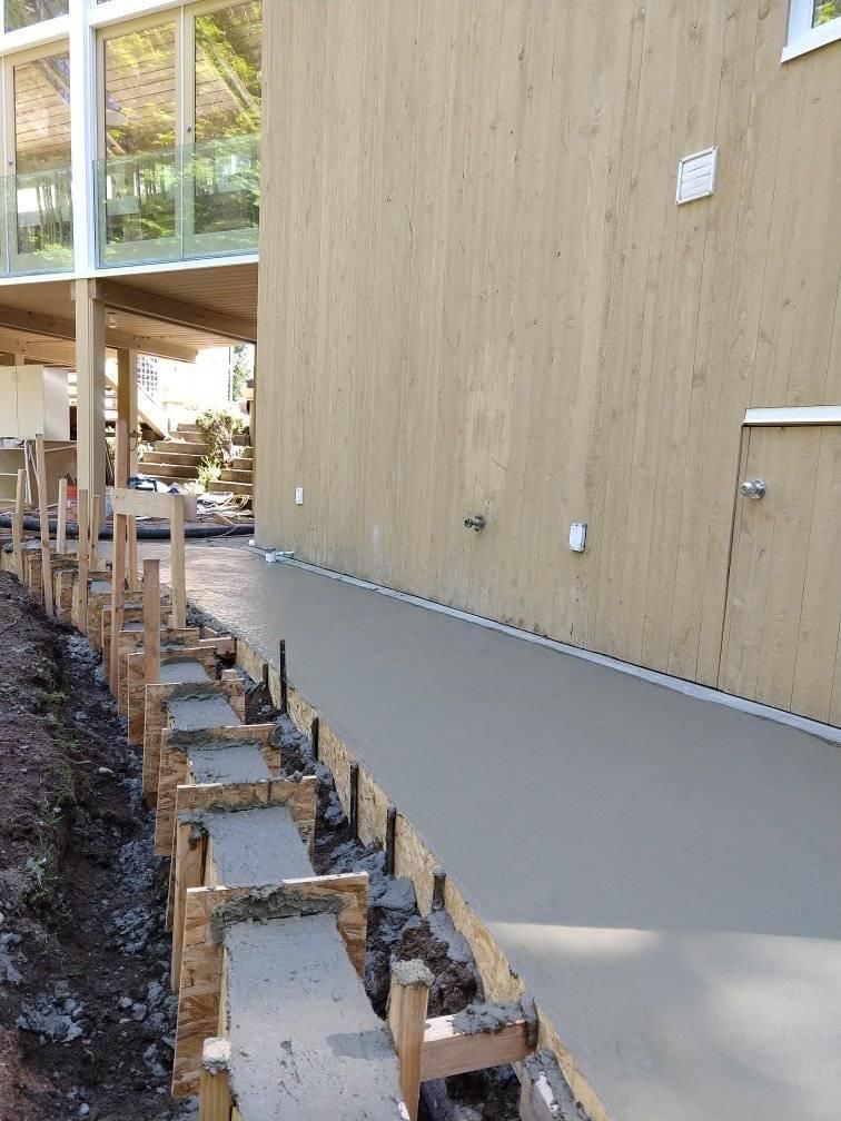 A concrete walkway is being built in front of a building.