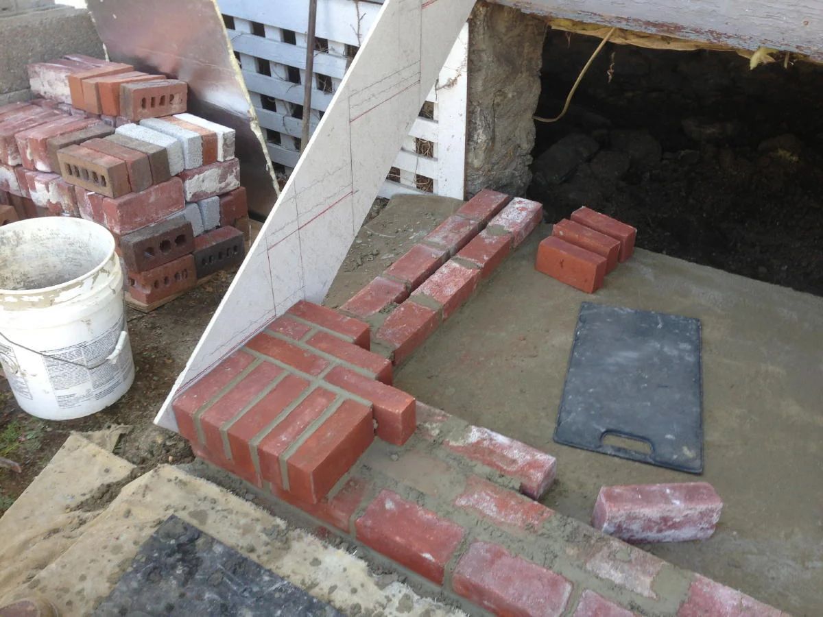 A pile of bricks and a bucket on the ground