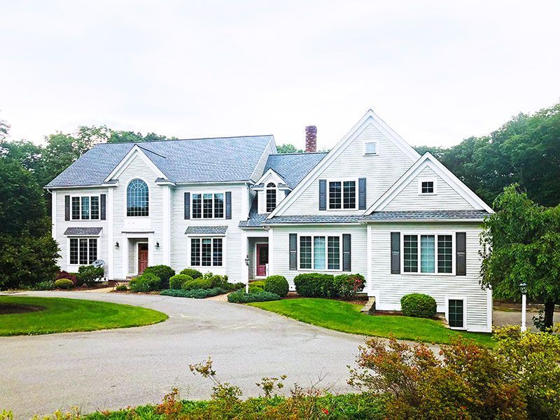 A large white house with a driveway leading to it