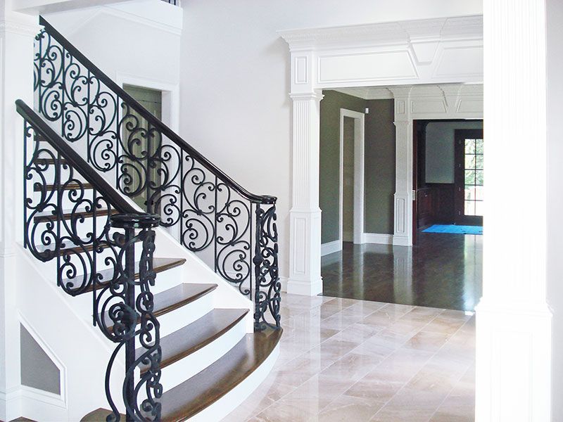 A curved staircase with a wrought iron railing