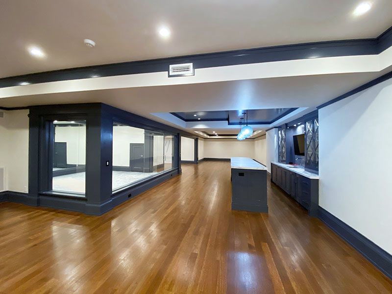 A large empty room with hardwood floors and white walls.