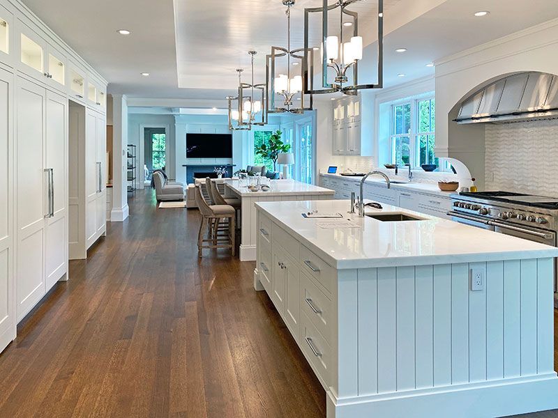 A large kitchen with white cabinets and a large island in the middle.