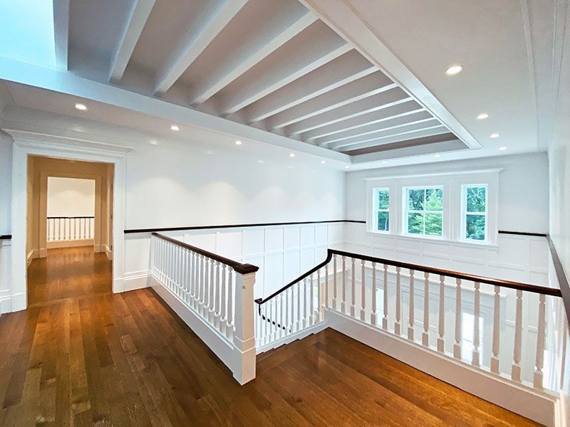 A staircase in a house with wooden floors and white railings