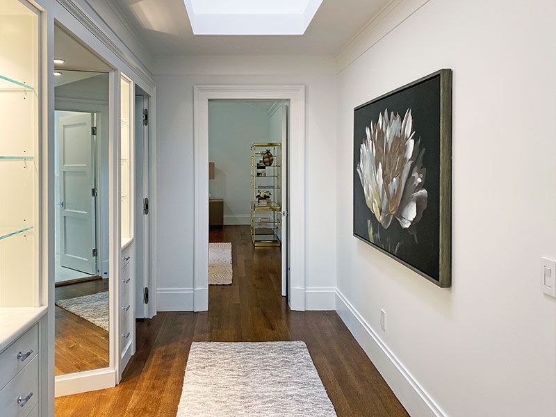 A hallway in a house with a painting on the wall.